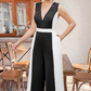 Elegant svartvit ärmlös jumpsuit med V-ringning och vida ben i kontrastfärger
